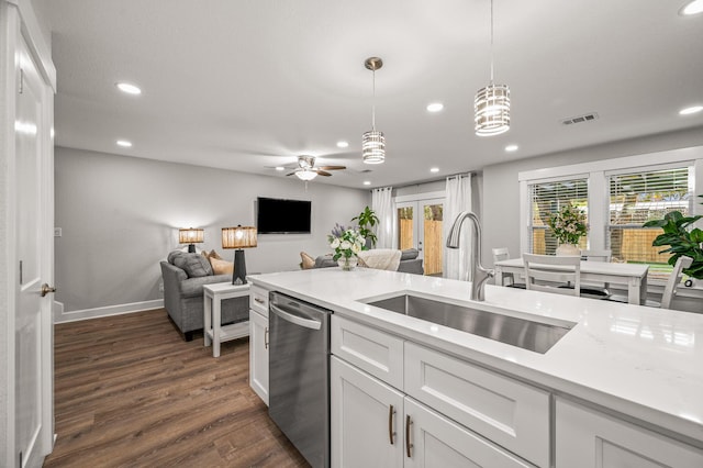 kitchen with visible vents, decorative light fixtures, dishwasher, white cabinetry, and a sink