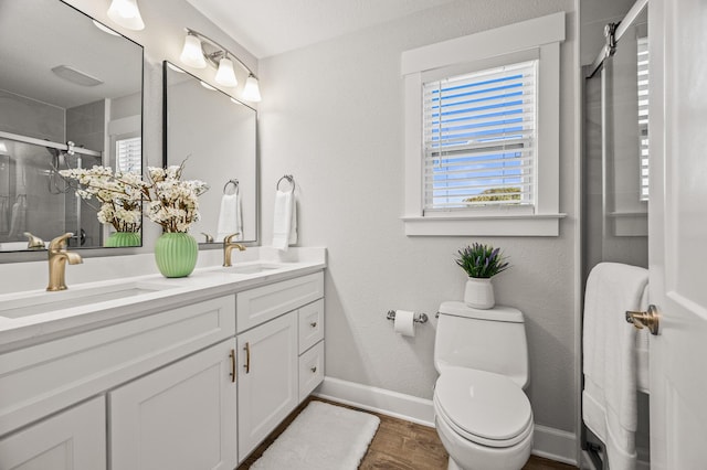 full bath with a sink, toilet, a stall shower, and double vanity