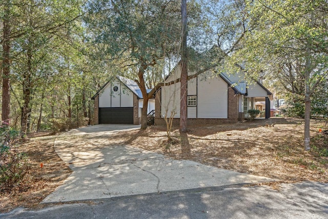 view of front of home featuring brick siding, concrete driveway, and a garage