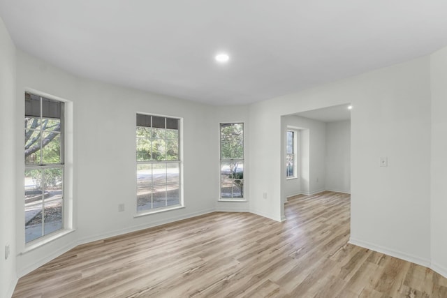 unfurnished room with recessed lighting, baseboards, plenty of natural light, and light wood finished floors