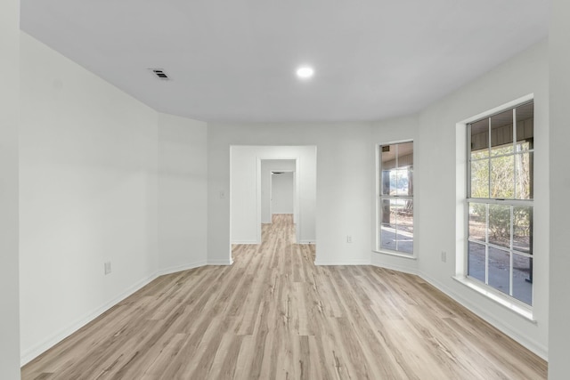 spare room featuring baseboards, visible vents, and light wood-type flooring