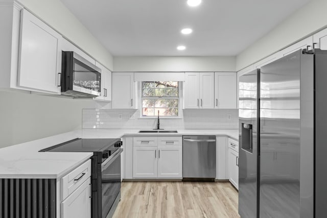 kitchen with white cabinetry, tasteful backsplash, appliances with stainless steel finishes, and a sink