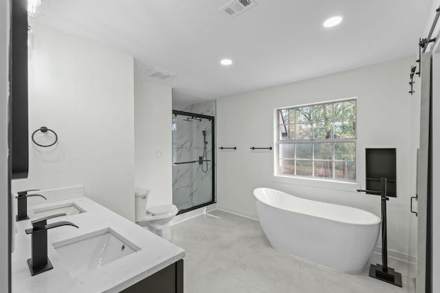 bathroom featuring a shower stall, double vanity, visible vents, and a sink