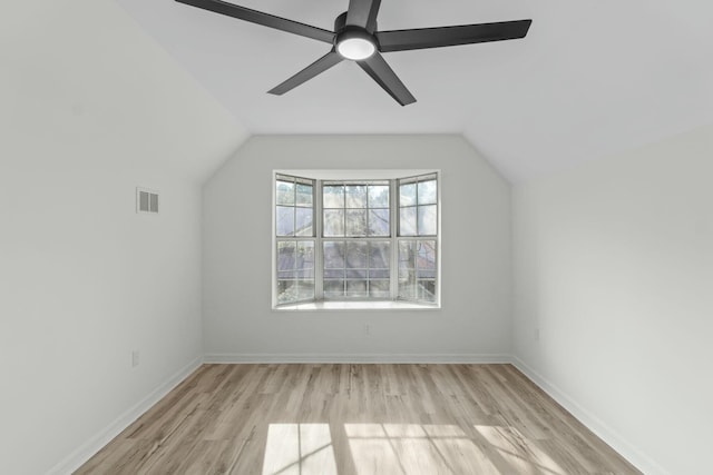 additional living space featuring light wood finished floors, visible vents, baseboards, vaulted ceiling, and a ceiling fan