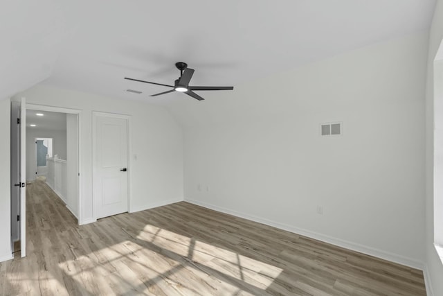 interior space featuring vaulted ceiling, wood finished floors, and visible vents