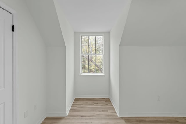 bonus room featuring baseboards, lofted ceiling, and light wood finished floors