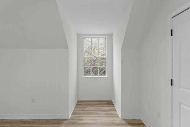 bonus room featuring vaulted ceiling, baseboards, and light wood-type flooring