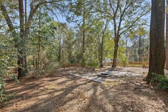 view of yard featuring a forest view and fence