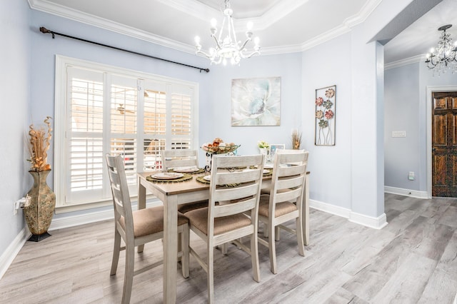 dining room with a chandelier, a healthy amount of sunlight, light wood finished floors, and crown molding