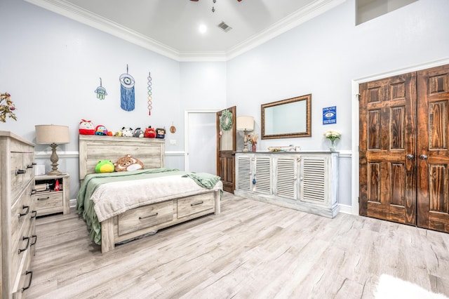 bedroom with visible vents, crown molding, baseboards, and wood finished floors