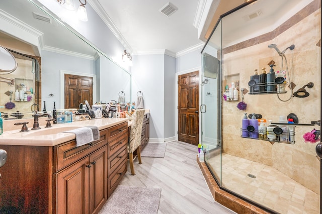 full bathroom with visible vents, a shower stall, wood finished floors, and crown molding