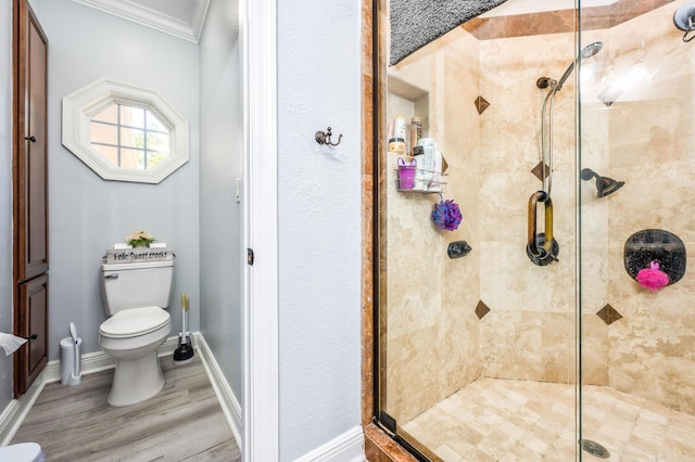 full bathroom with baseboards, toilet, a stall shower, and crown molding