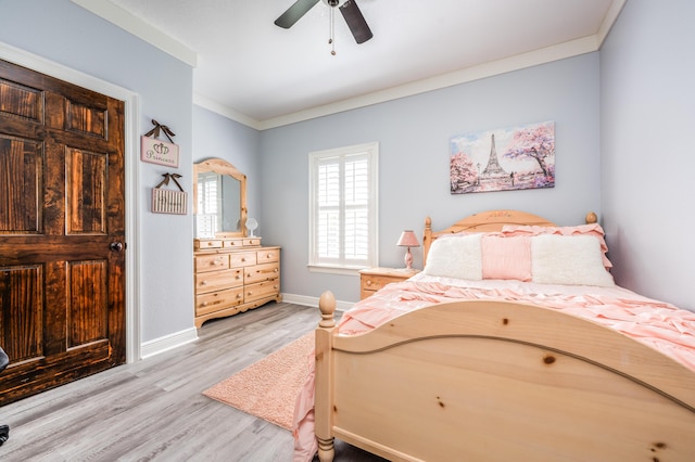 bedroom with crown molding, light wood-style flooring, a ceiling fan, and baseboards