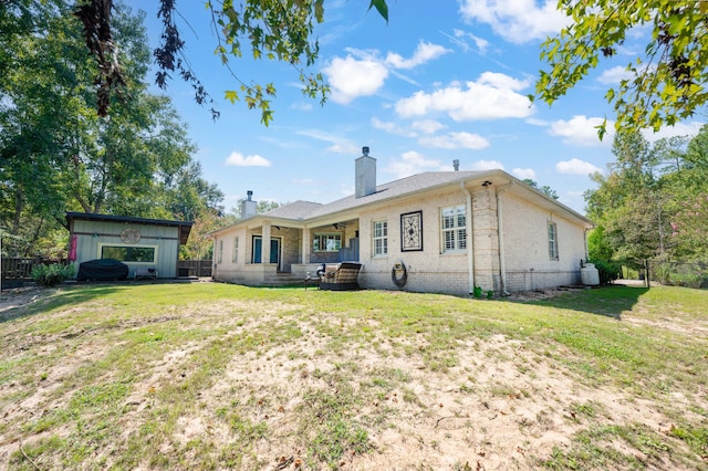 rear view of house featuring a yard, a chimney, and fence