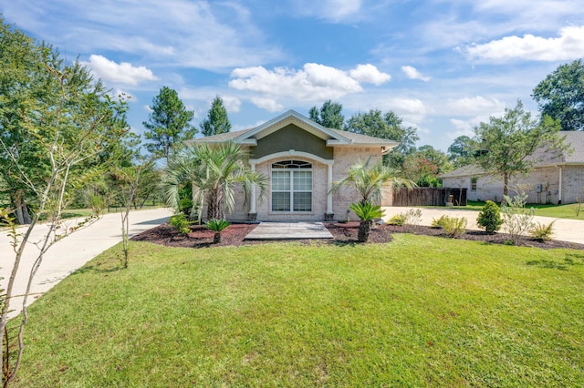 view of front facade featuring stucco siding, concrete driveway, a front lawn, and fence