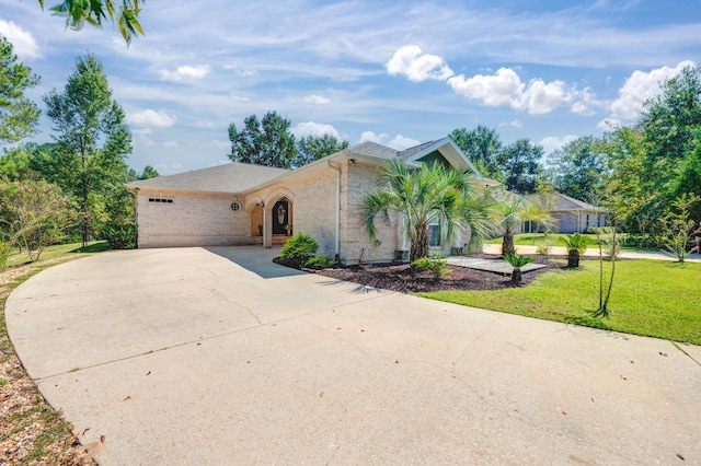 view of front of house with concrete driveway, brick siding, and a front lawn