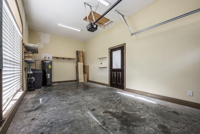 garage featuring baseboards, electric water heater, and a garage door opener