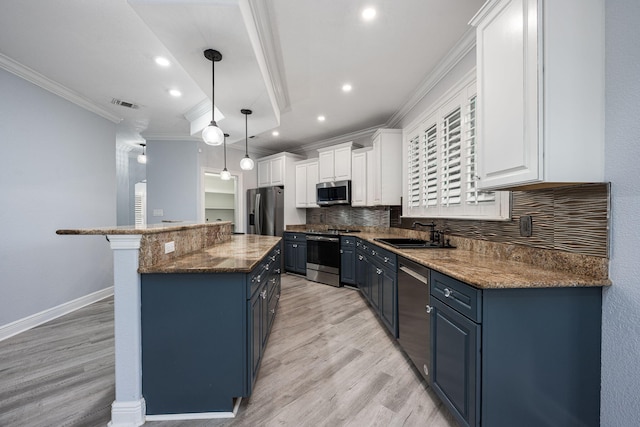 kitchen featuring visible vents, ornamental molding, appliances with stainless steel finishes, blue cabinets, and a sink