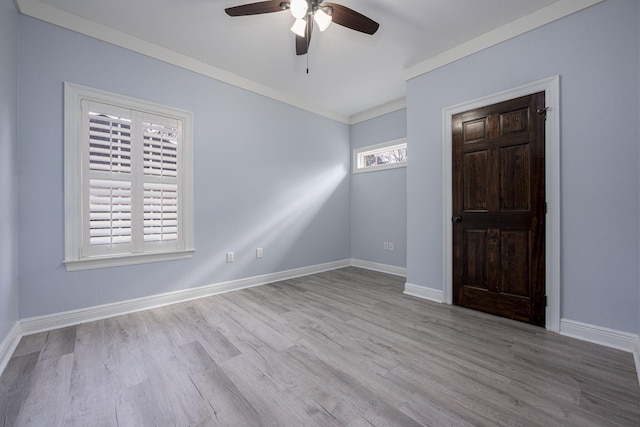 spare room featuring ornamental molding, baseboards, ceiling fan, and wood finished floors