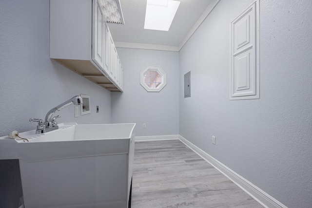 laundry room featuring baseboards, washer hookup, light wood-style flooring, cabinet space, and hookup for an electric dryer