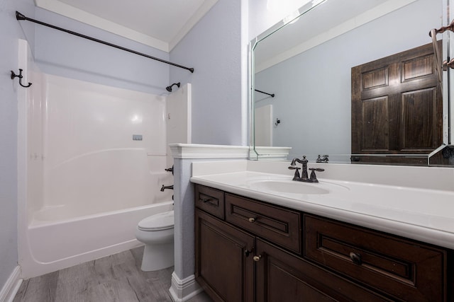 full bathroom featuring toilet, ornamental molding, wood finished floors, bathing tub / shower combination, and vanity