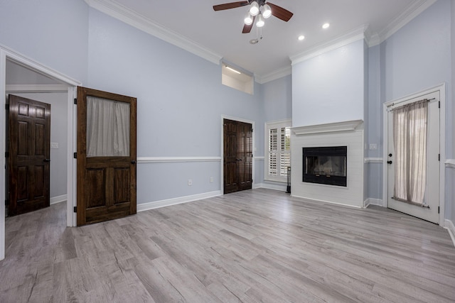 unfurnished living room with light wood finished floors, baseboards, crown molding, and a ceiling fan