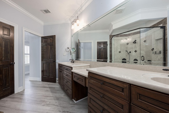 bathroom with visible vents, a shower stall, ornamental molding, wood finished floors, and vanity