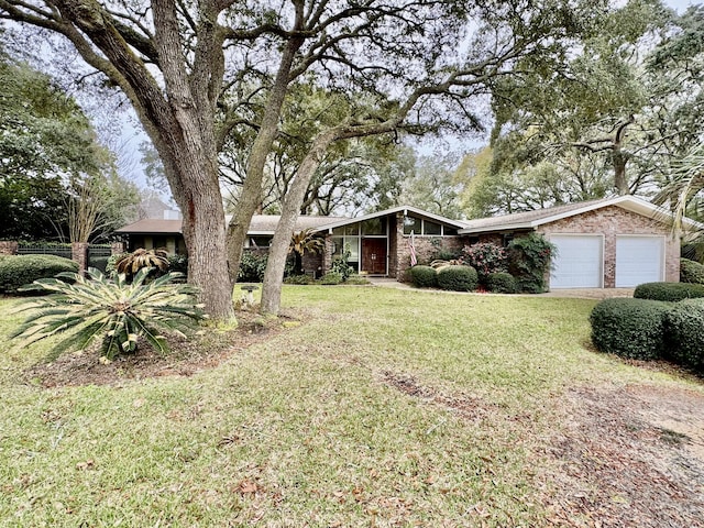 mid-century modern home with brick siding, an attached garage, and a front lawn