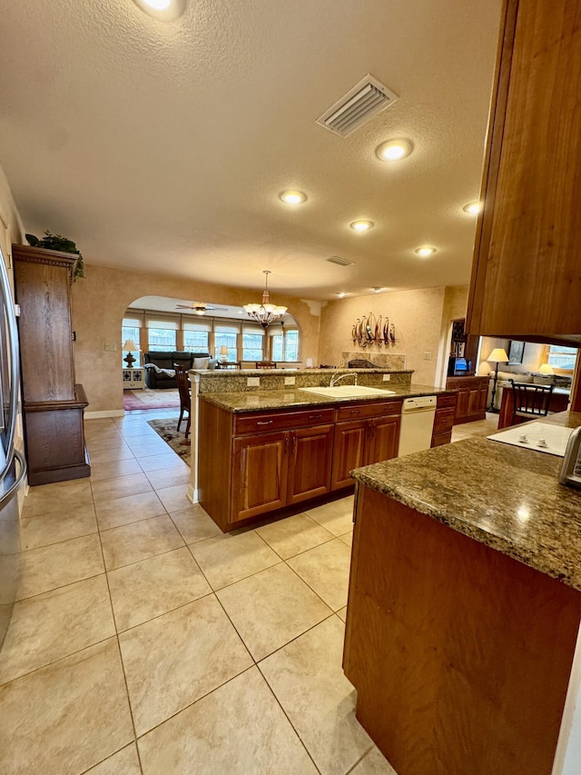 kitchen featuring dishwasher, light tile patterned flooring, arched walkways, and visible vents