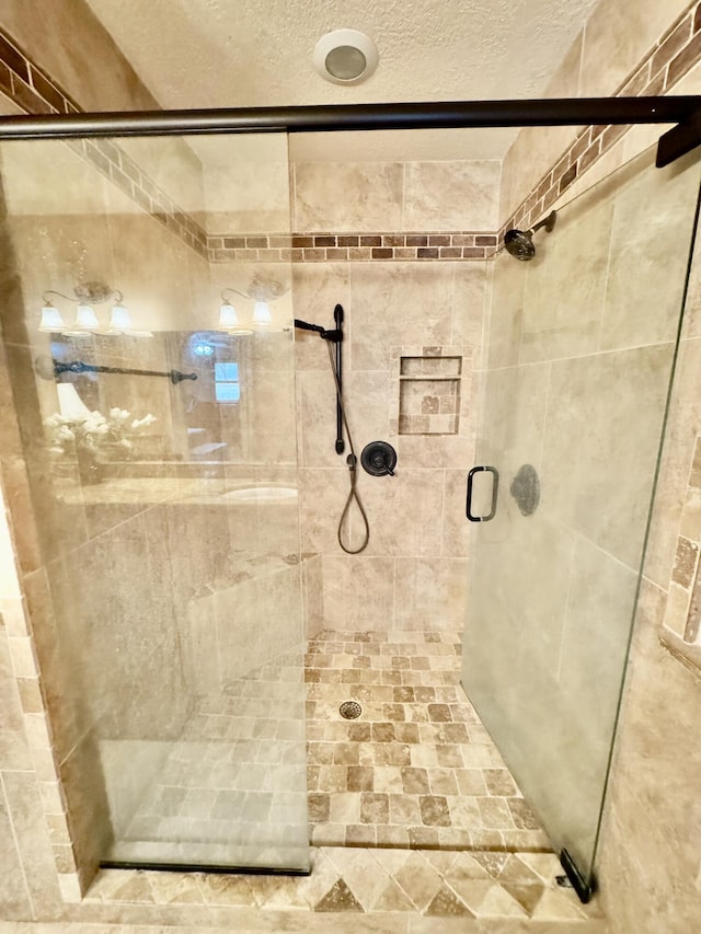 full bathroom featuring a stall shower and a textured ceiling