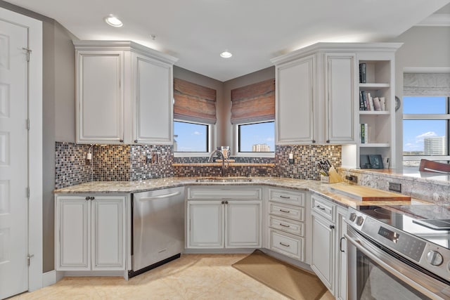 kitchen with a sink, backsplash, light stone countertops, appliances with stainless steel finishes, and open shelves