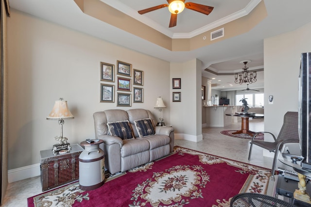 tiled living room with visible vents, ceiling fan with notable chandelier, baseboards, crown molding, and a raised ceiling