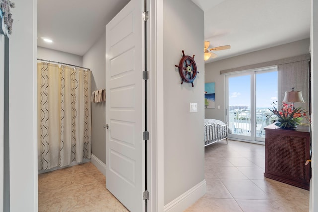 hallway with light tile patterned floors and baseboards