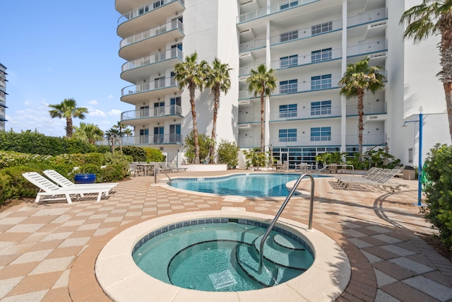 community pool featuring a patio and a hot tub