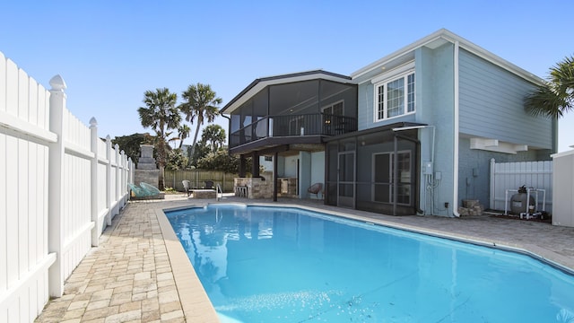 view of swimming pool featuring a fenced in pool, a patio, a fenced backyard, and a sunroom