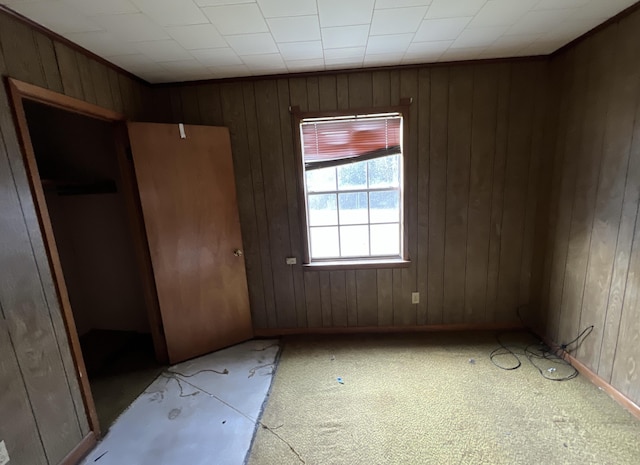 unfurnished bedroom featuring wooden walls and a closet