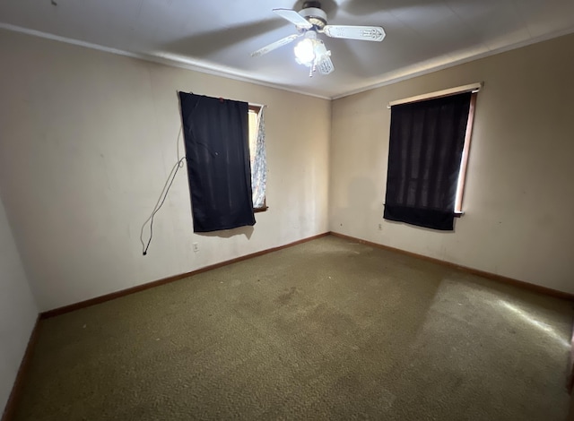 carpeted spare room featuring baseboards and ceiling fan