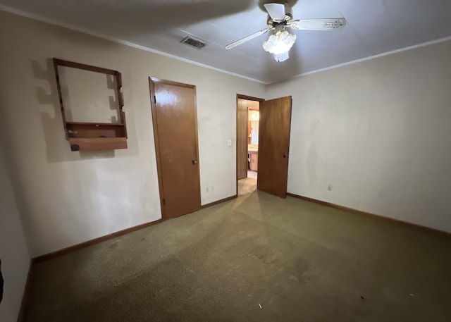 unfurnished bedroom featuring visible vents, a ceiling fan, carpet, crown molding, and baseboards