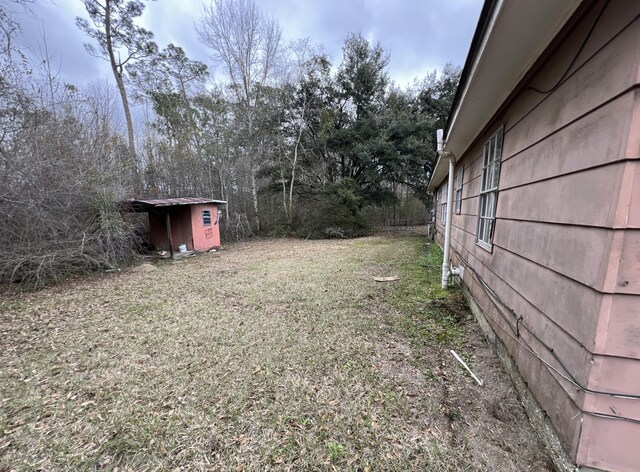 view of yard with a storage shed and an outbuilding