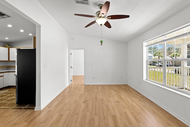 unfurnished room featuring visible vents, light wood-style flooring, baseboards, and a ceiling fan