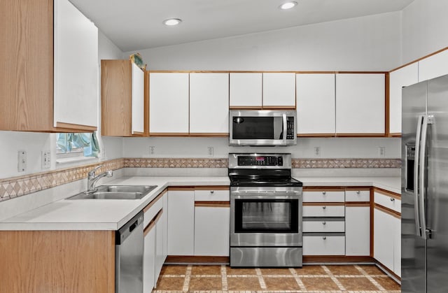 kitchen with recessed lighting, a sink, light countertops, white cabinets, and appliances with stainless steel finishes