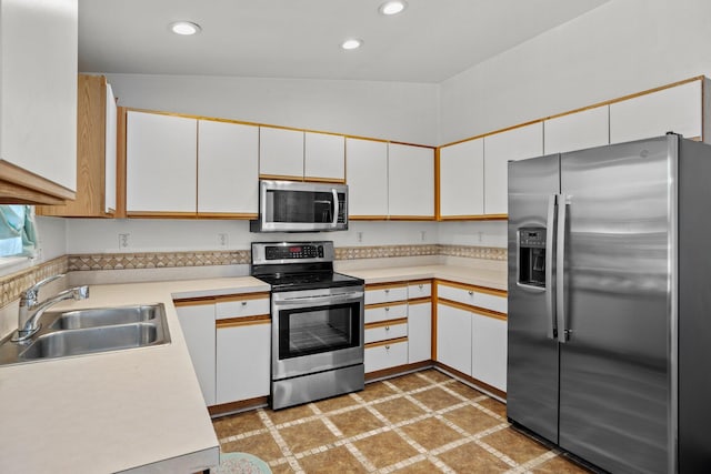 kitchen featuring a sink, recessed lighting, appliances with stainless steel finishes, light countertops, and light floors