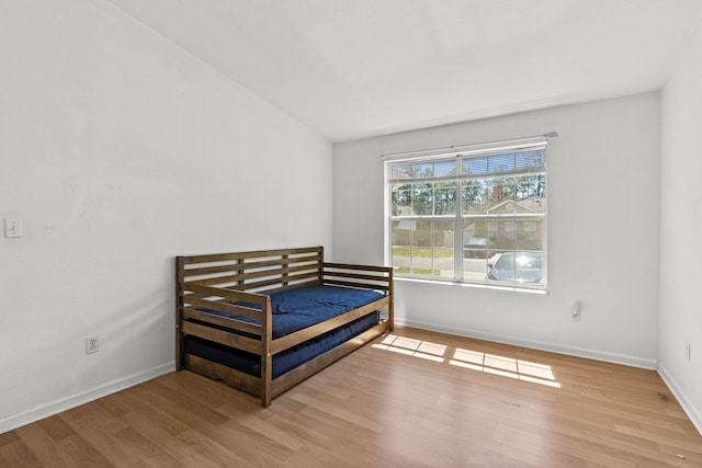 bedroom with baseboards and wood finished floors