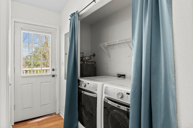 washroom with light wood-type flooring, independent washer and dryer, and laundry area