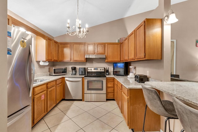 kitchen featuring under cabinet range hood, stainless steel appliances, light stone counters, and light tile patterned floors