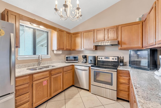 kitchen featuring under cabinet range hood, vaulted ceiling, light tile patterned floors, stainless steel appliances, and a sink