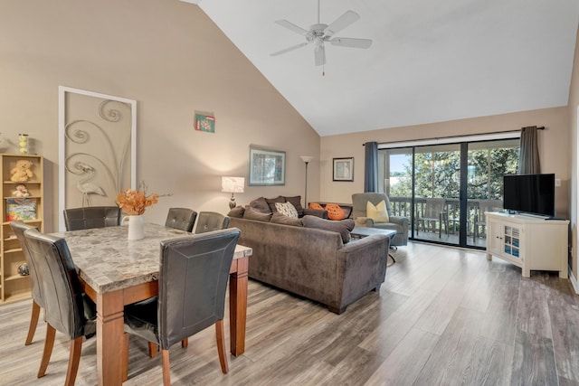 dining room featuring high vaulted ceiling, light wood-type flooring, and ceiling fan