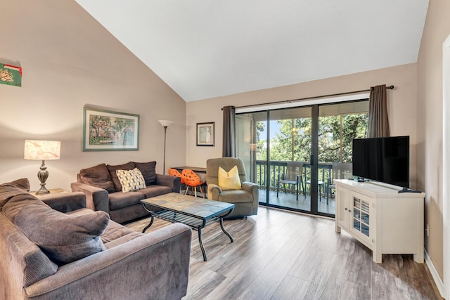 living room featuring high vaulted ceiling and light wood-style flooring