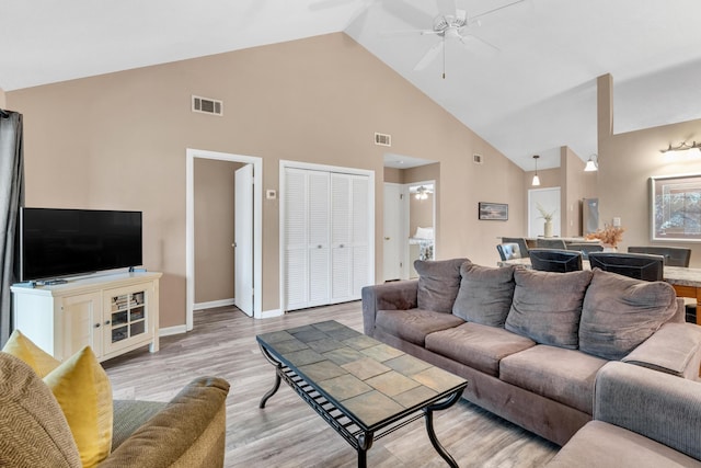 living area featuring visible vents, baseboards, light wood-style flooring, and a ceiling fan