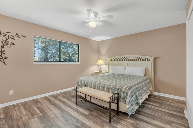 bedroom with ceiling fan, baseboards, and wood finished floors